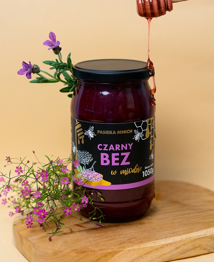 Duży słoik miodu z czarnym bzem 1050g Pasieka Mnich z miodem ściekającym z nabieraka.